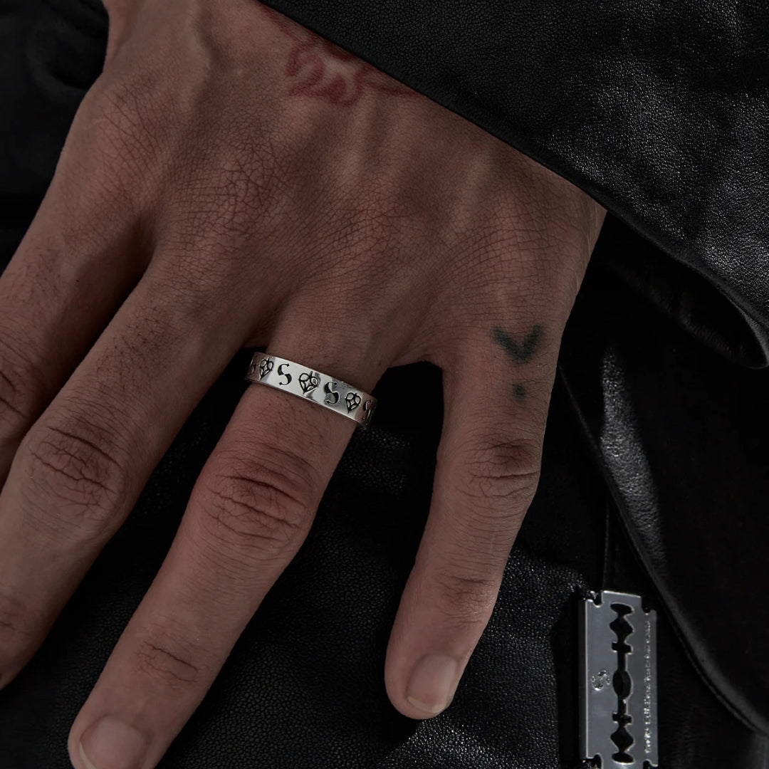 It's a classic for a reason. Celestial hearts combine with their S-logo in their new imprint band. This narrow band style ring is made from sterling silver with dark oxidised detailing.